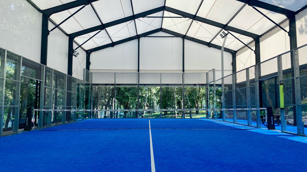 Indoor padel court with blue surface and glass walls