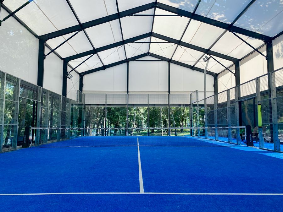 Cancha de pádel indoor con superficie azul
