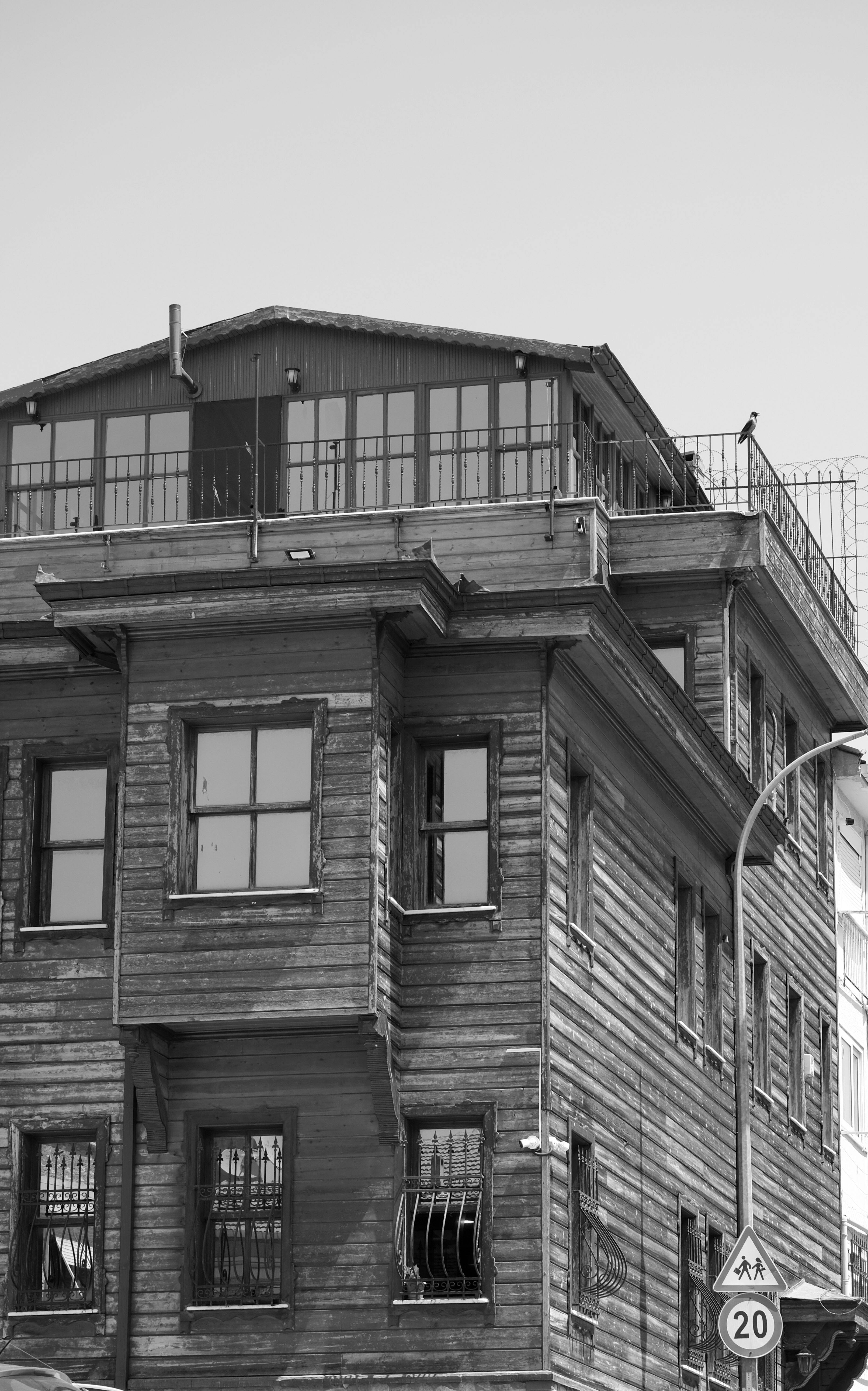 Ücretsiz Üzerinde tabela ve sokak lambası bulunan tarihi ahşap bir binanın siyah beyaz fotoğrafı. Stok Fotoğraflar