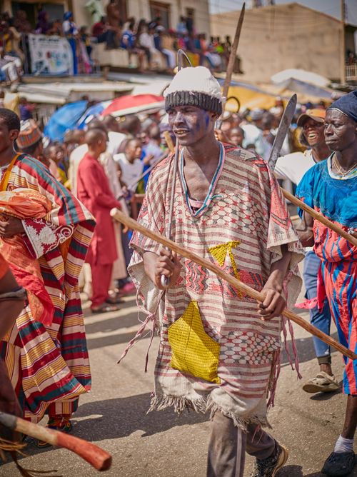 Free Participants in vibrant cultural attire march in an African street parade. Stock Photo