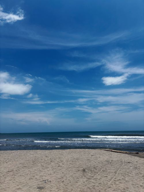 Free A serene beach scene with blue sky and gentle waves, perfect for relaxation. Stock Photo
