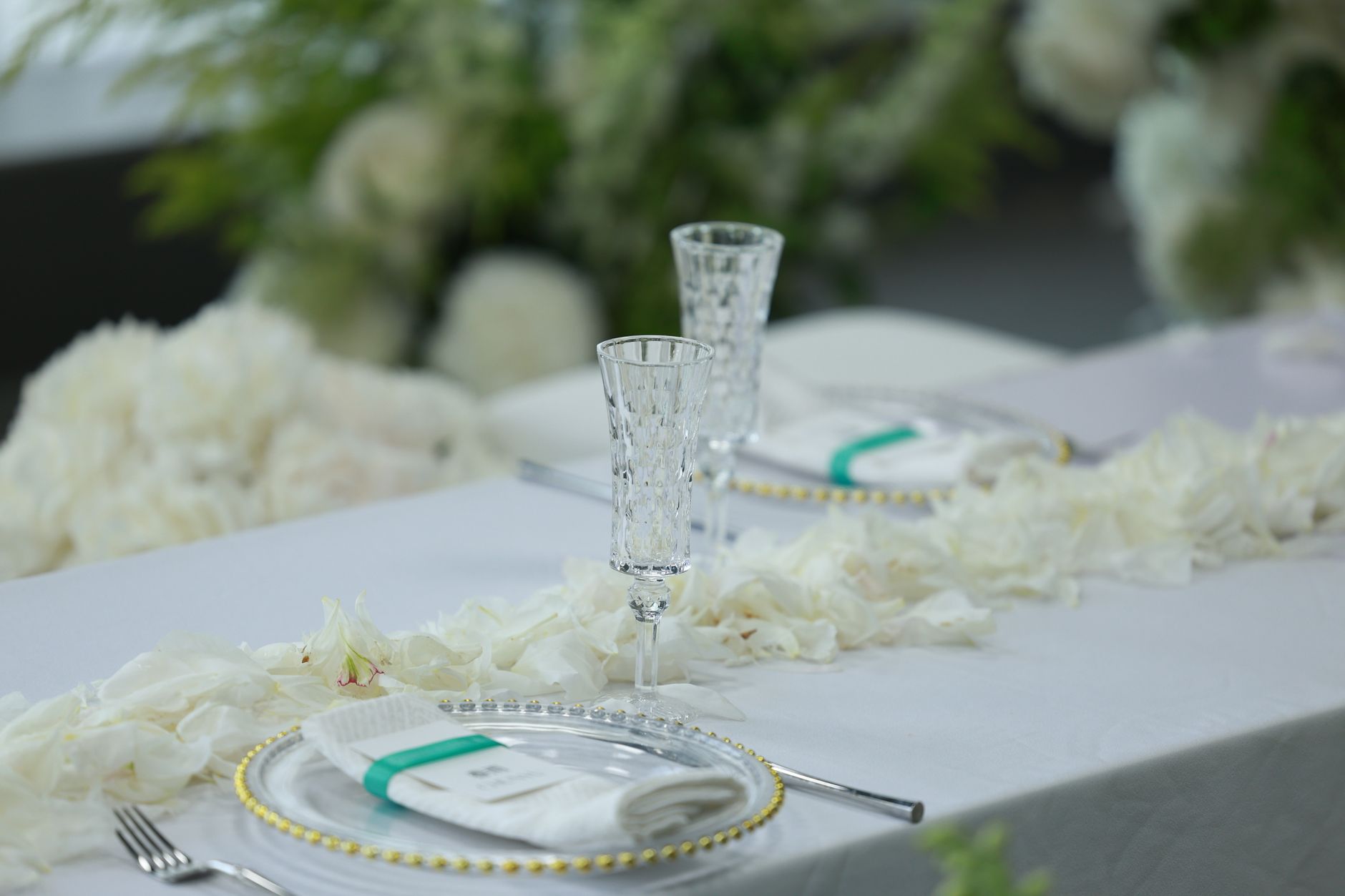 Elegant wedding table setup featuring crystal glasses, white flowers, and a classic table arrangement.