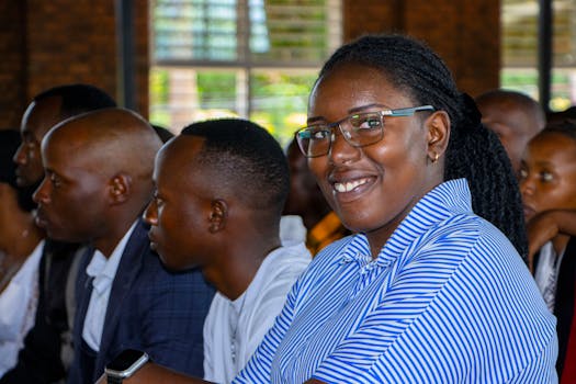 A group of diverse adults attending an indoor event with focus on a smiling woman.