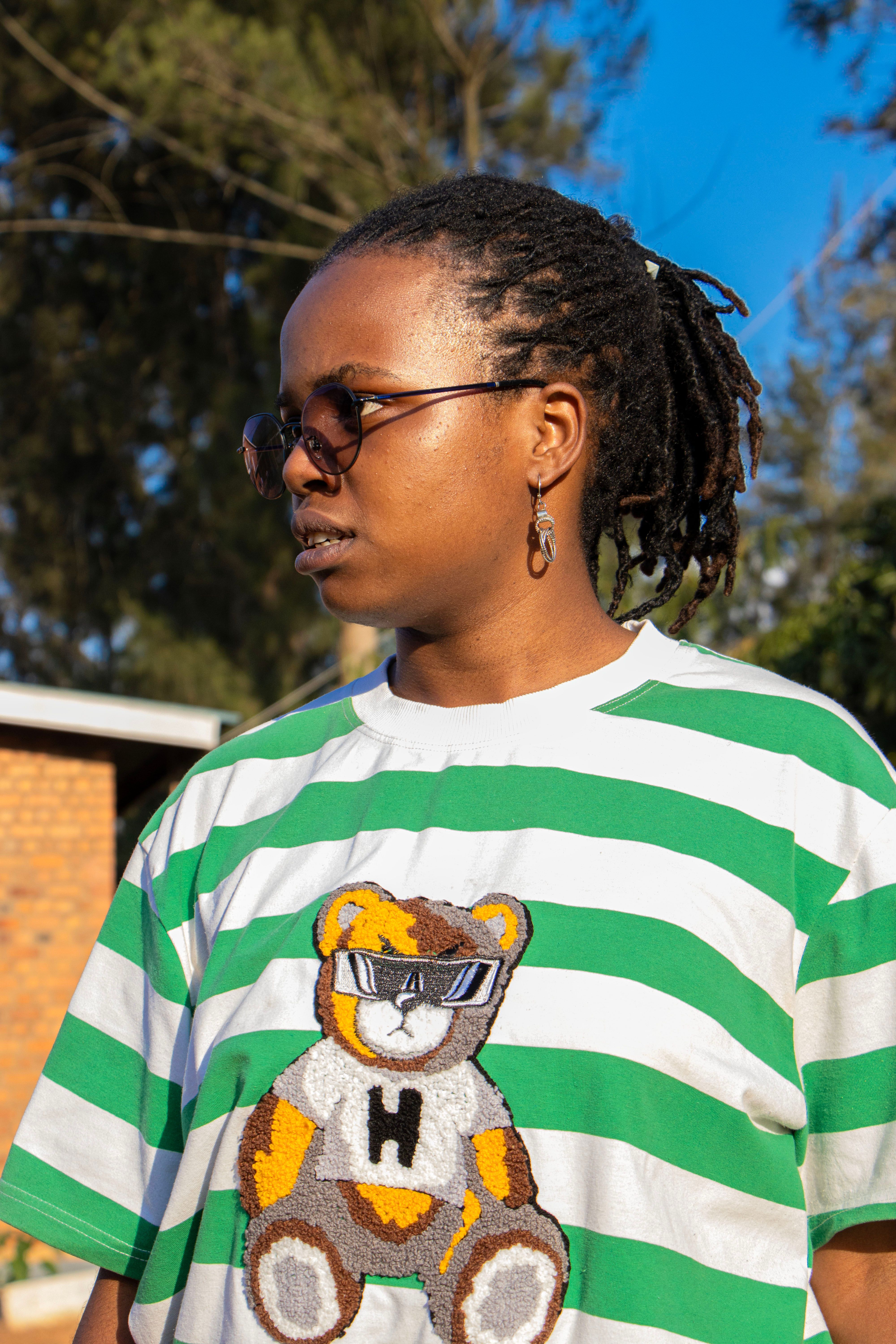 Casual portrait of a young adult outdoors wearing sunglasses and a teddy bear design shirt.
