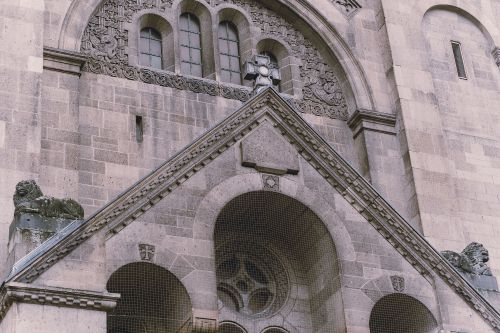 Free Close-up view of an ornate church facade with decorative stone carvings and arched windows. Stock Photo