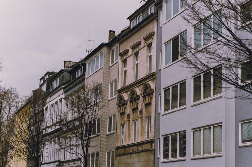 Free A row of urban European apartment buildings with diverse facades in an overcast setting. Stock Photo