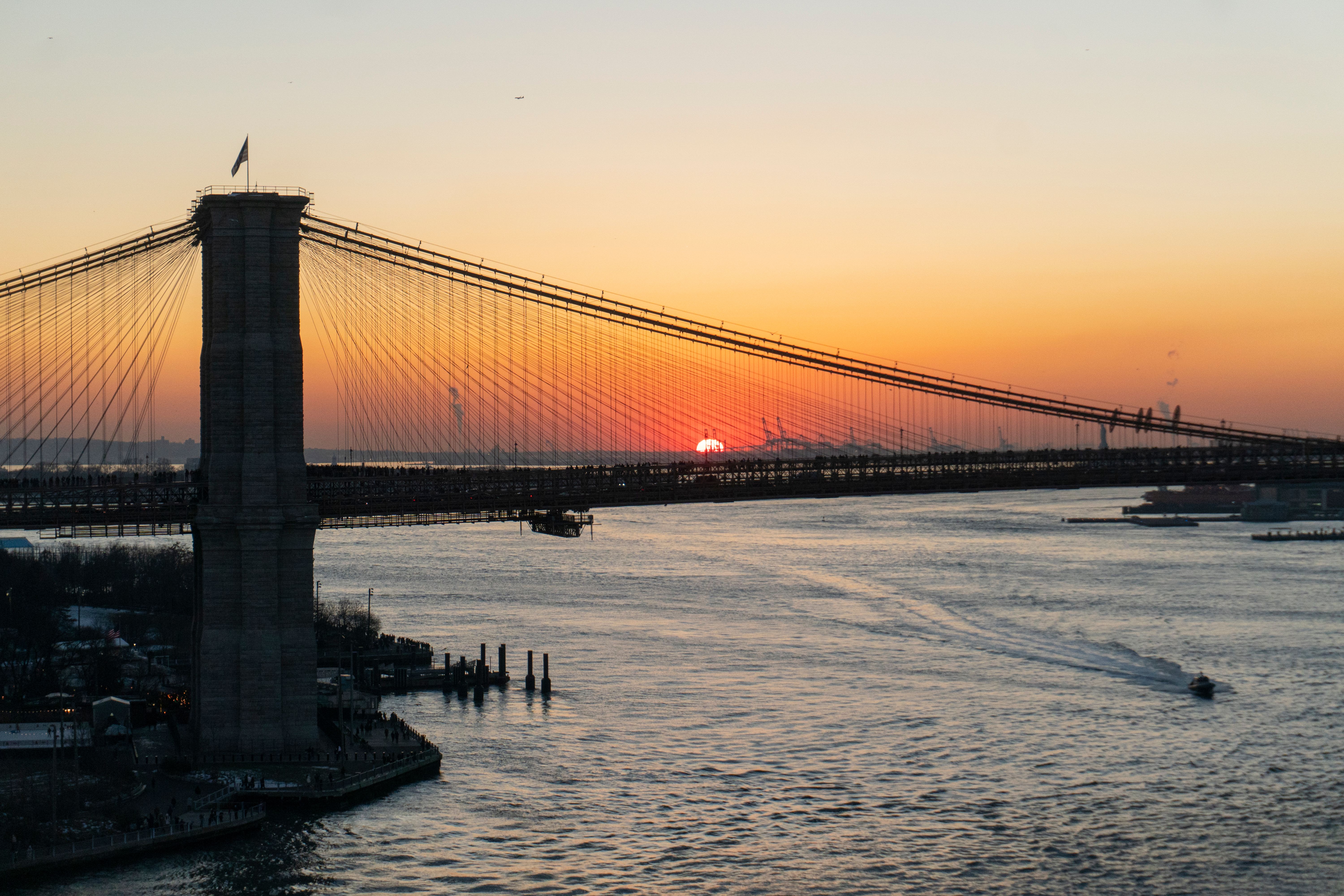 Scenic view of the Brooklyn Bridge with a vibrant sunset over New York City's skyline. - New River Gorge