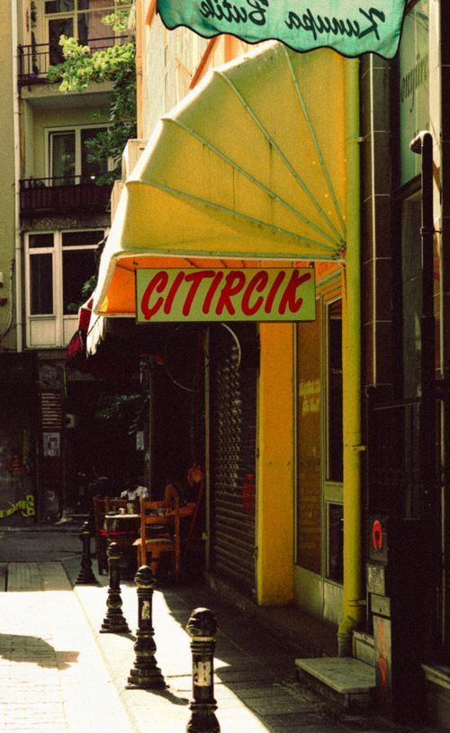 Free Sunlit urban café street view with 'CITIRCIK' sign, capturing cozy city ambiance. Stock Photo