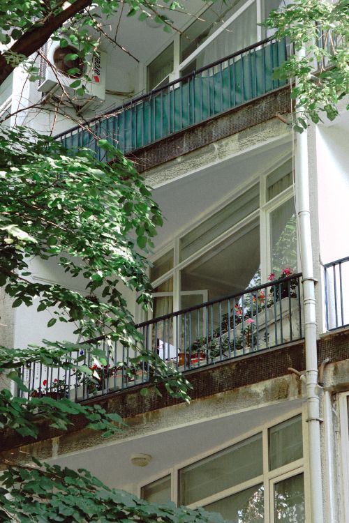 Free A modern building facade with balconies adorned with plants and flowers. Stock Photo