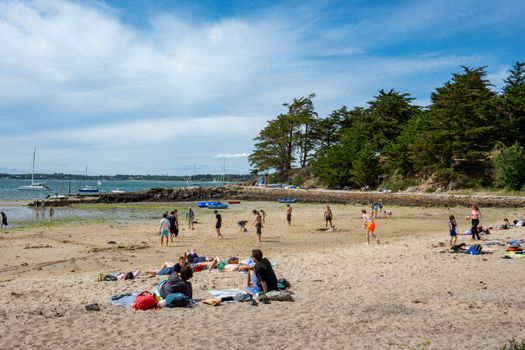People enjoying a sunny day at the beach in Île-aux-Moines, Brittany, France.