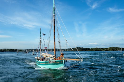Traditional sailboat navigating Brittany's picturesque waters under a clear blue sky.