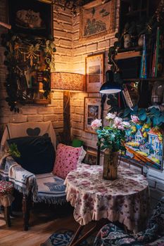 Charming vintage living room corner with floral decor and warm lighting creating a cozy ambiance.