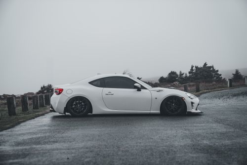 Free A white sports car parked in a foggy outdoor setting, showcasing modern design. Stock Photo