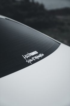 Close-up of a car window with a sticker saying 'Hard Work Pays Off' in a minimalist, moody setting.