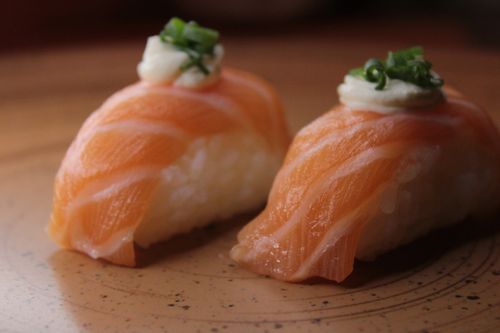 Free Delicious fresh salmon nigiri sushi with rice and garnish. Perfect for Japanese cuisine enthusiasts. Stock Photo