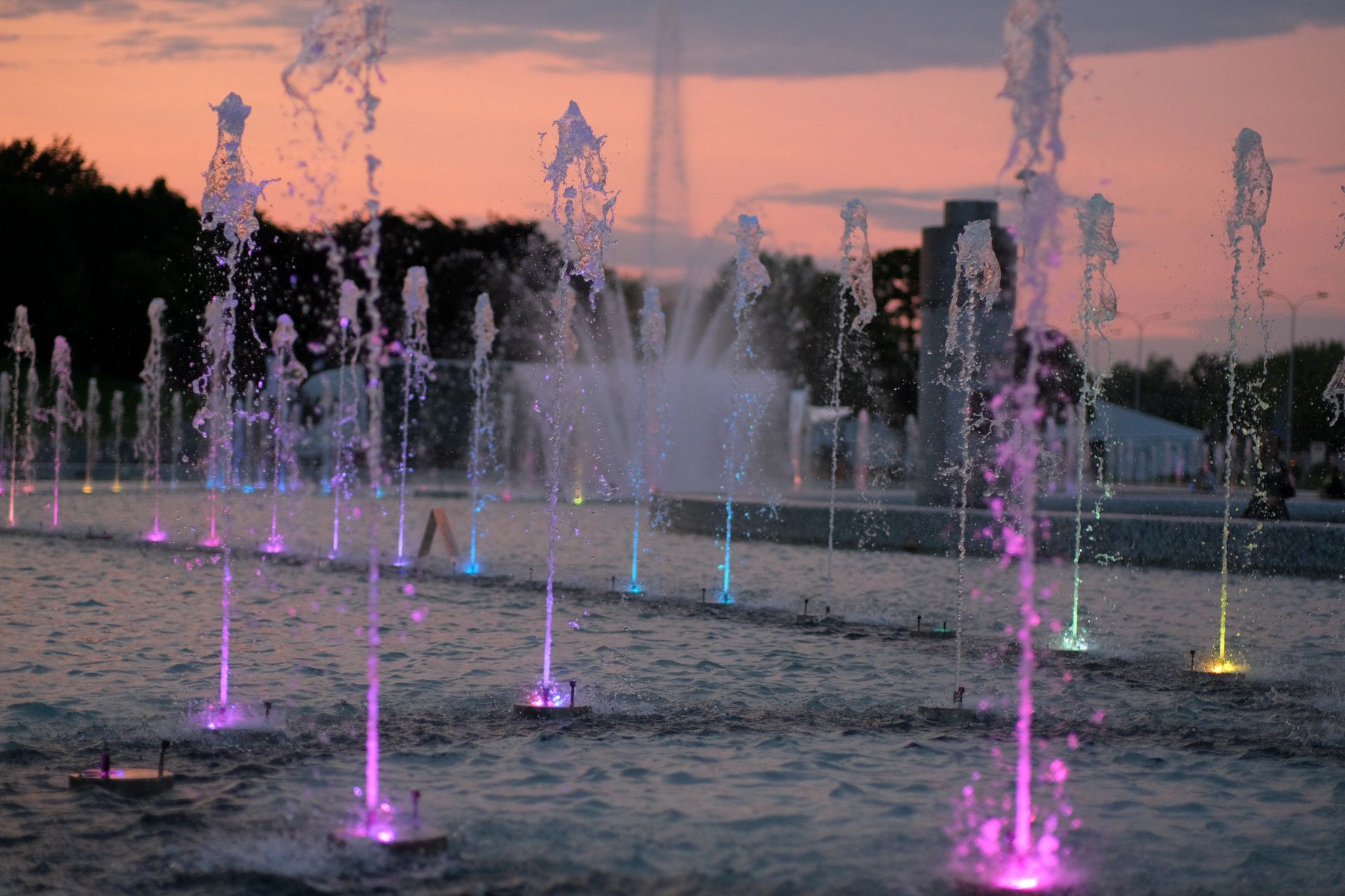 Vibrant colored fountains at sunset, creating a magical and serene atmosphere.