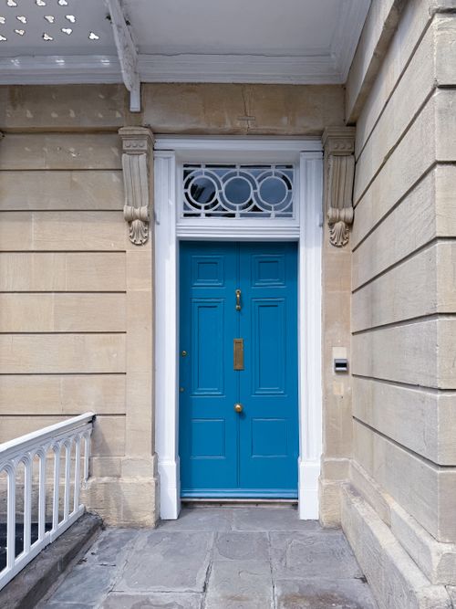 Free A striking blue door set in classical architecture, showcasing historic English elegance. Stock Photo