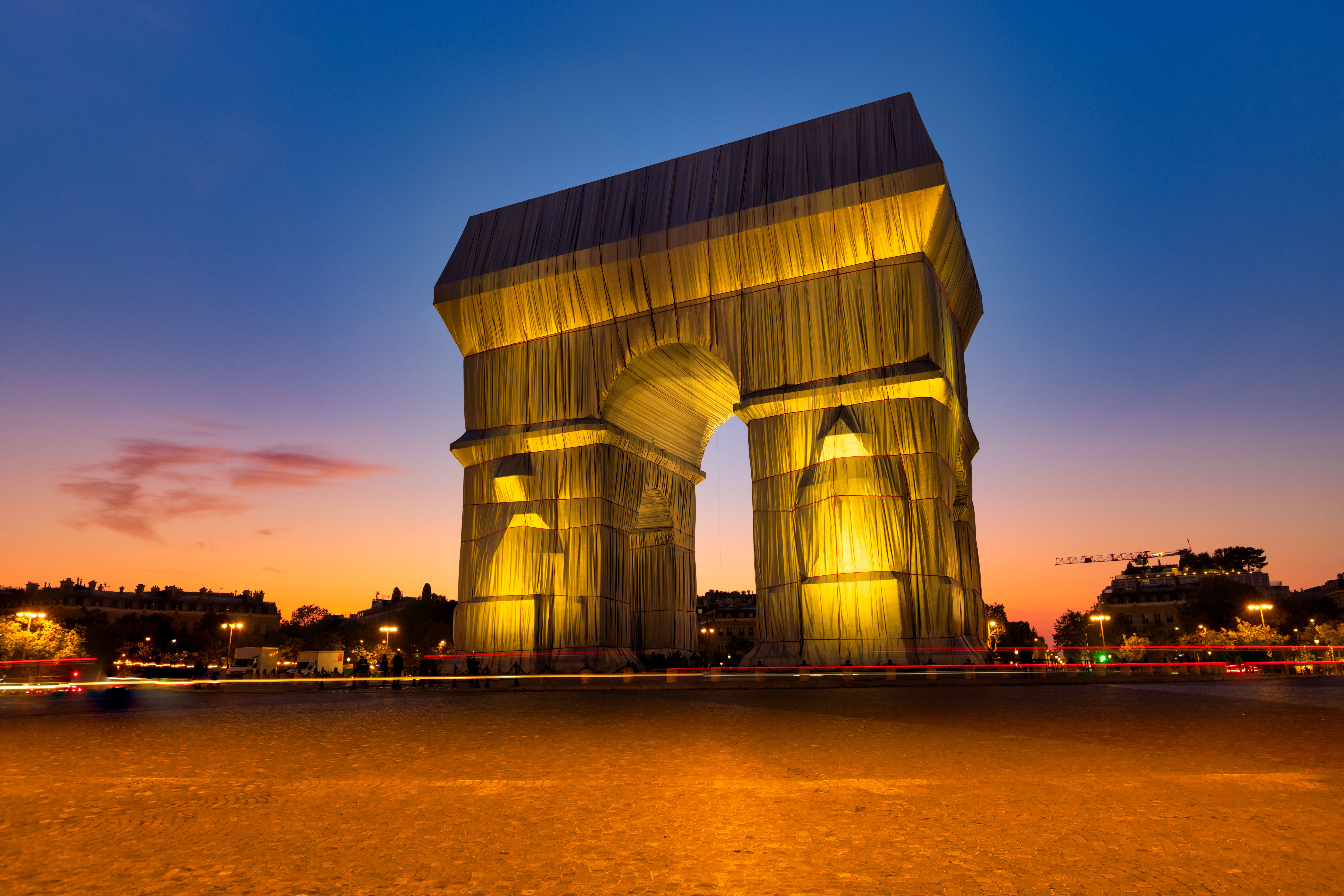 Gratis Pemandangan menakjubkan Arc de Triomphe yang terbungkus kain saat matahari terbenam, memamerkan seni di Paris. Foto Stok