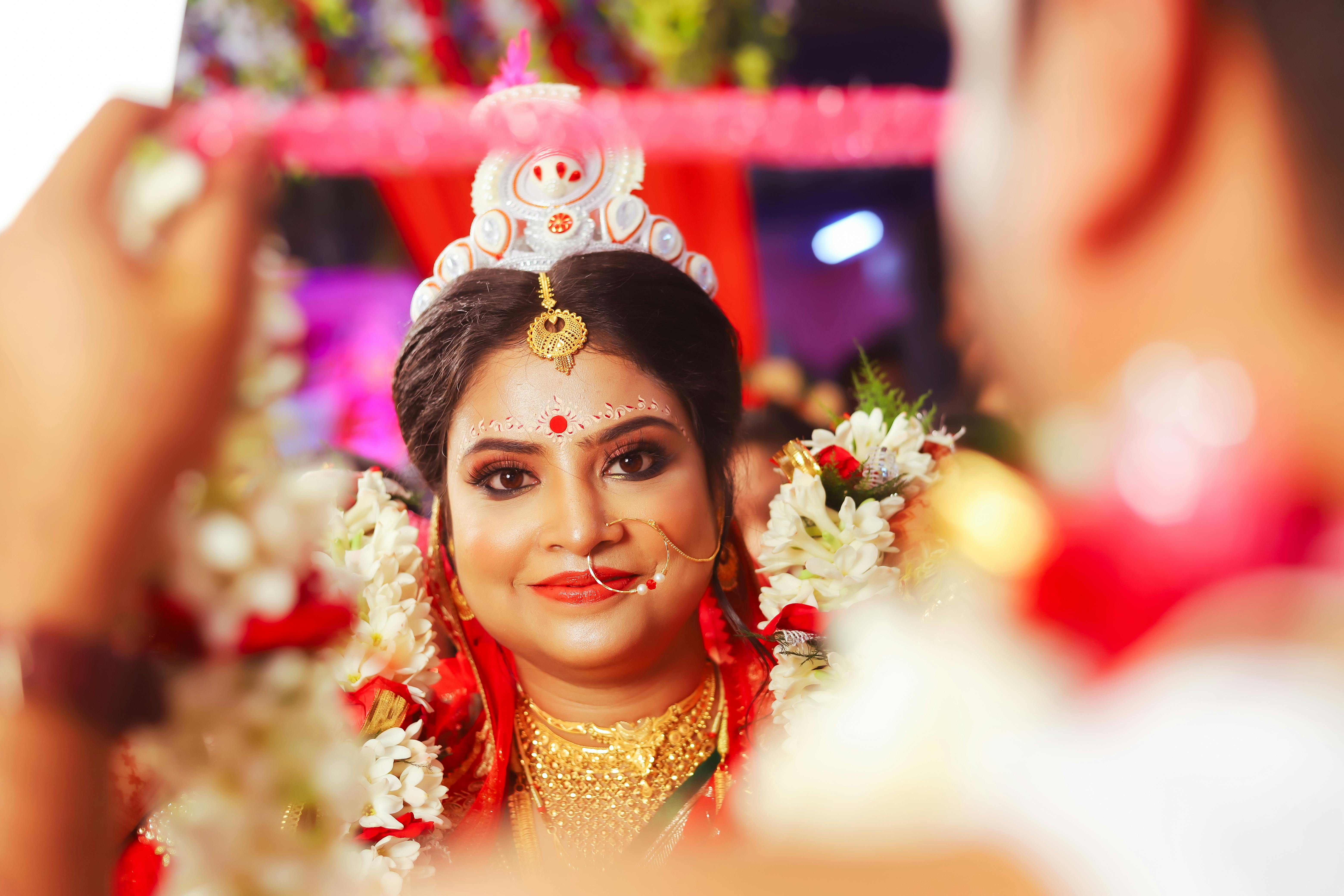 Captivating portrait of an Indian bride smiling in vibrant traditional wedding attire, reflecting cultural beauty.