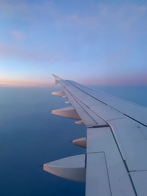 Free Tranquil aerial view of an airplane wing at sunrise, showcasing a serene sky. Stock Photo