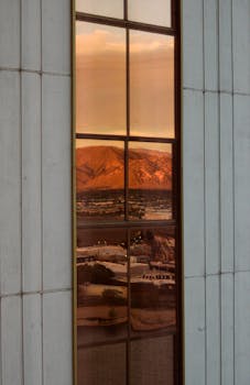 Reflected view of Reno mountains during sunset through a modern building window.