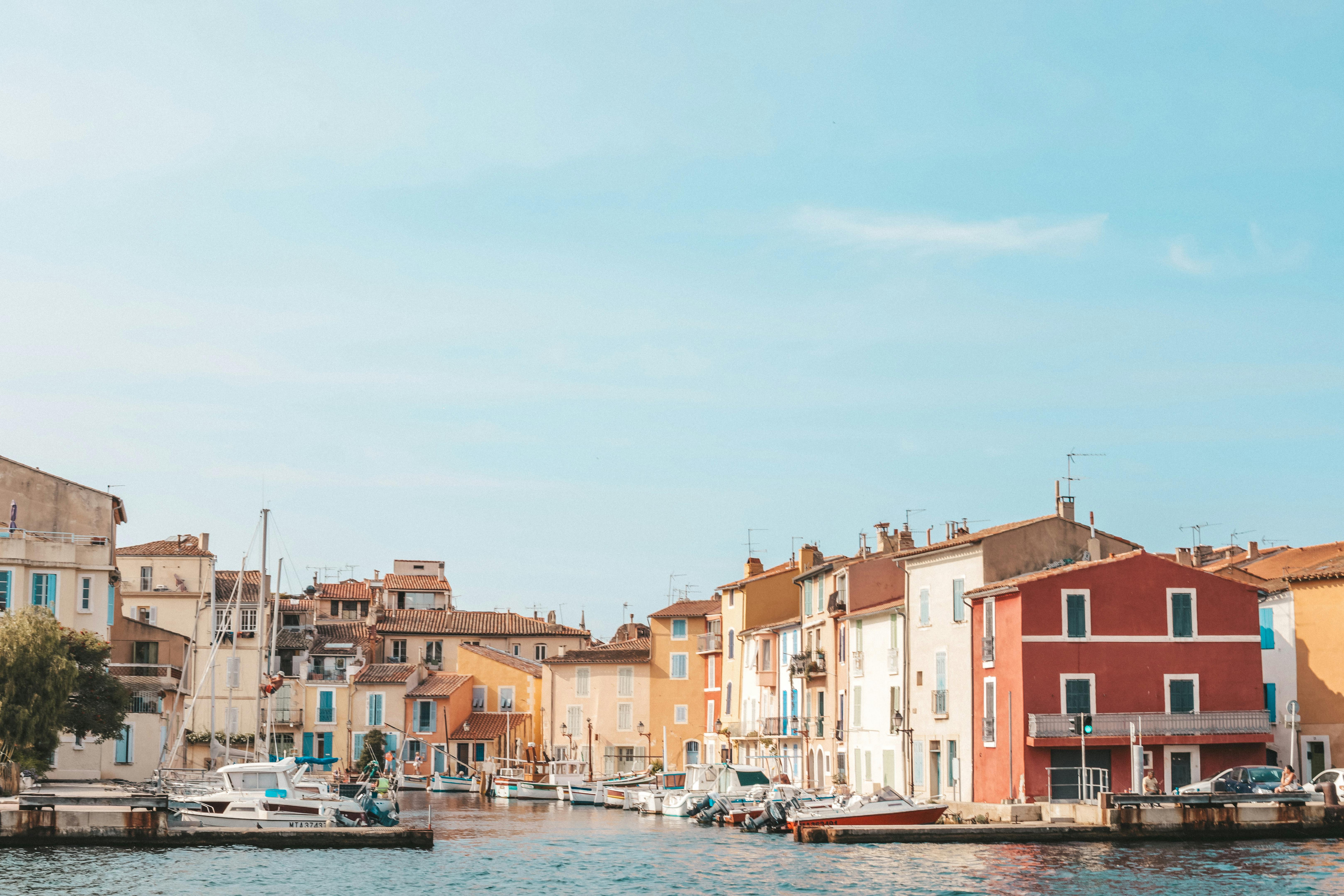Beautiful waterfront scene with colorful houses and boats on a sunny day.