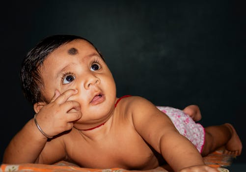 Charming baby portrait with a curious look, perfect for family and lifestyle themes.