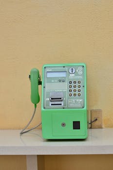 A classic green Japanese payphone set against a peach wall. Shot in Urayasu, Chiba.