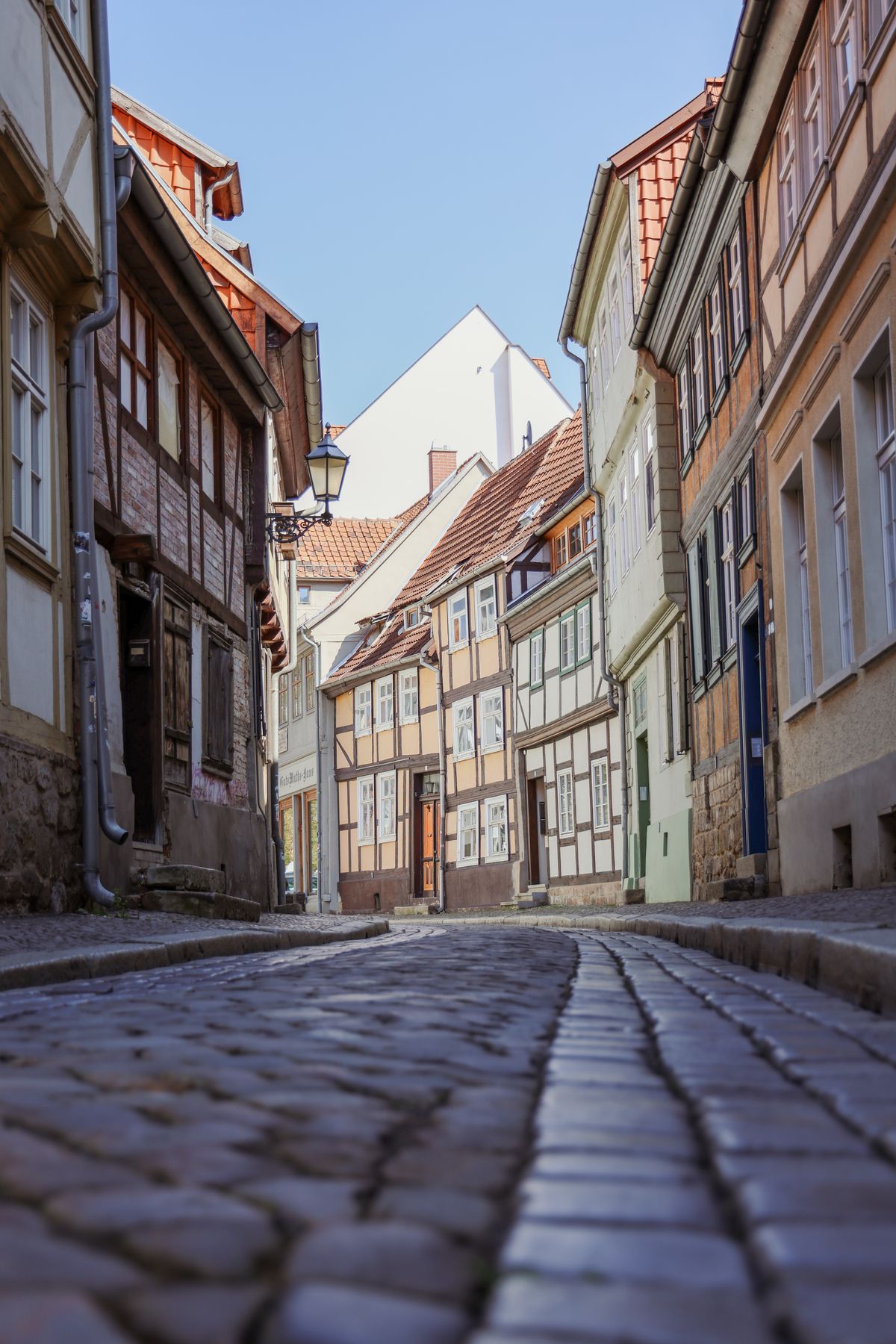 Charming cobblestone street lined with traditional half-timbered houses in a historic town, for a local trivia round, trivia night party ideas