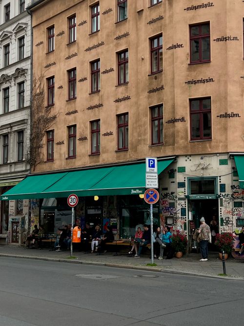 Free Outdoors street cafe in Berlin, vibrant graffiti, people enjoying the urban atmosphere. Stock Photo