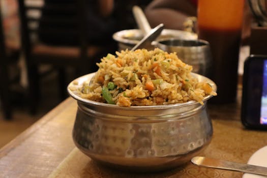 A flavorful serving of Indian fried rice with vegetables in a traditional metal bowl, ideal for food enthusiasts.