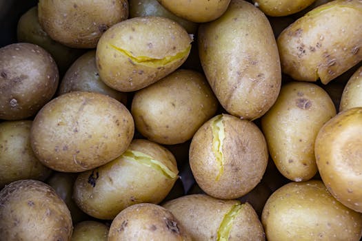 A detailed view of cooked yellow potatoes with cracked skin, showcasing texture and freshness.