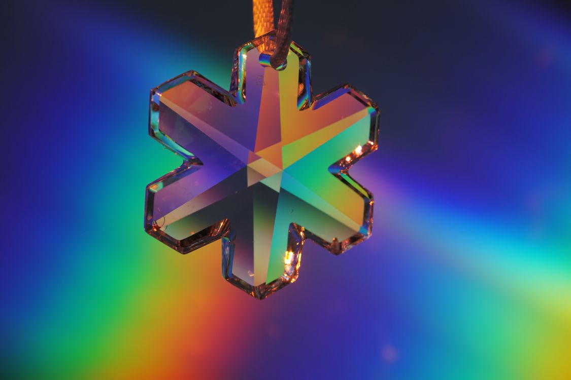 crystal snowflake ornament reflecting rainbow colours in the light