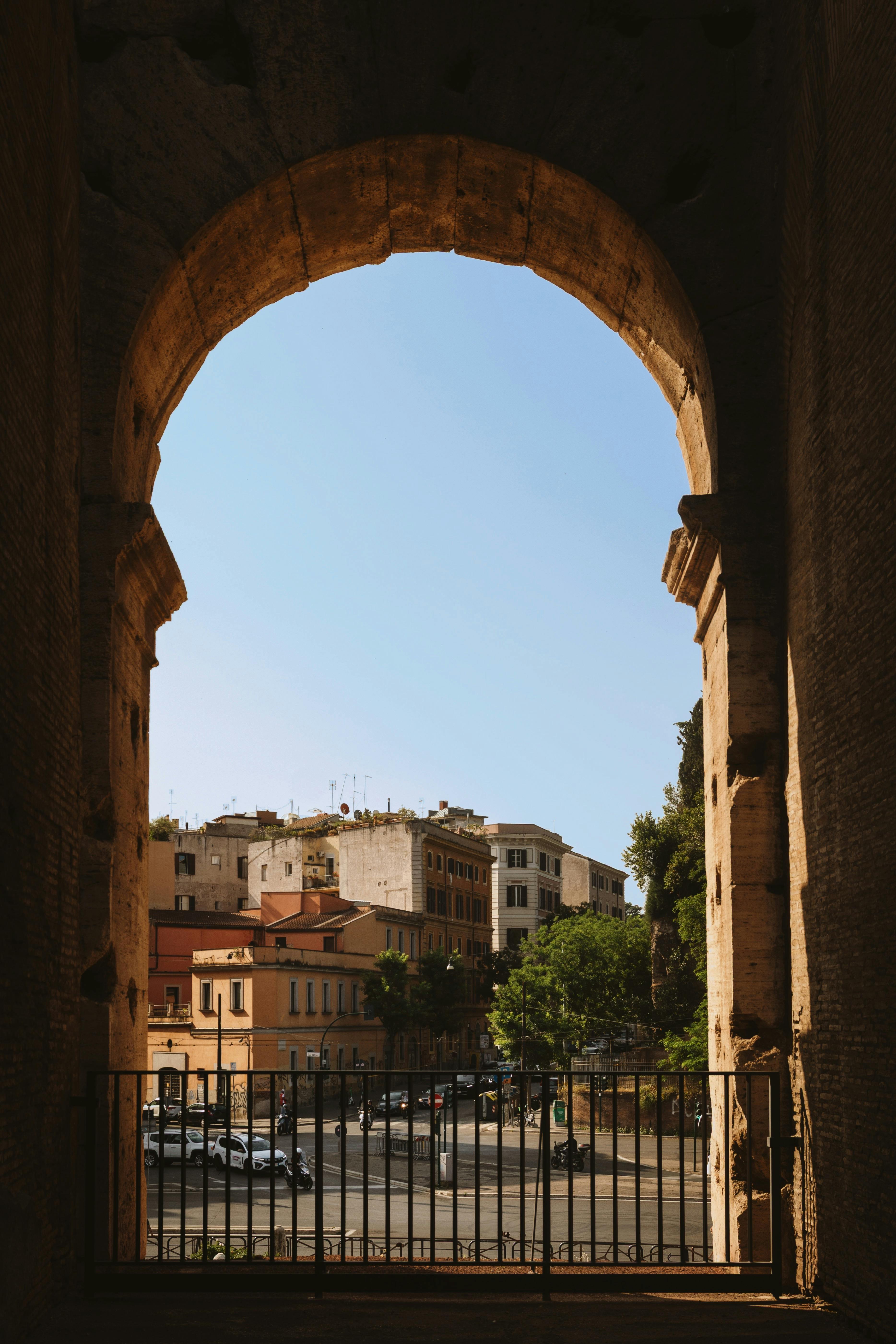 Scenic view of Rome buildings from inside a historic arch, Lazio, Italy.
