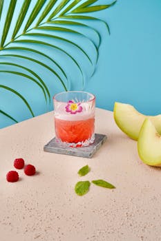 Vibrant summer drink with melon, raspberries, and mint on a stylish setting.