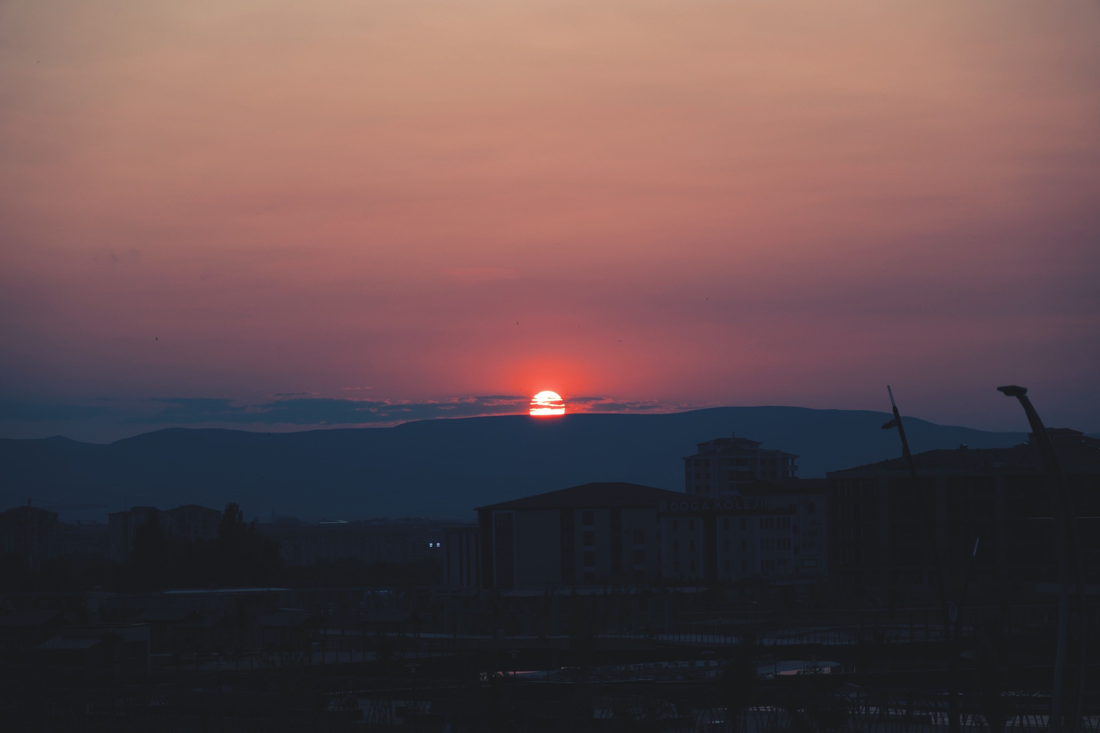 Serene Sunset Over City Skyline in Twilight · Free Stock Photo