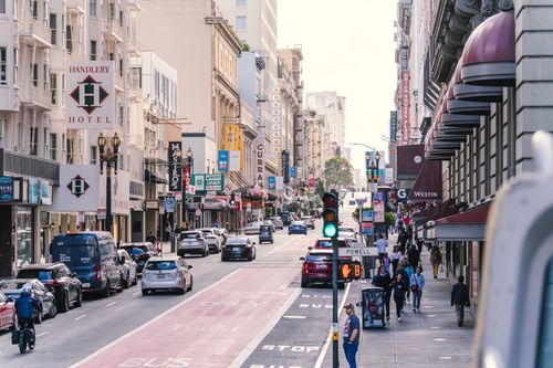 grátis Vista urbana animada da Geary Street, no centro de São Francisco, com trânsito e pedestres. Foto profissional