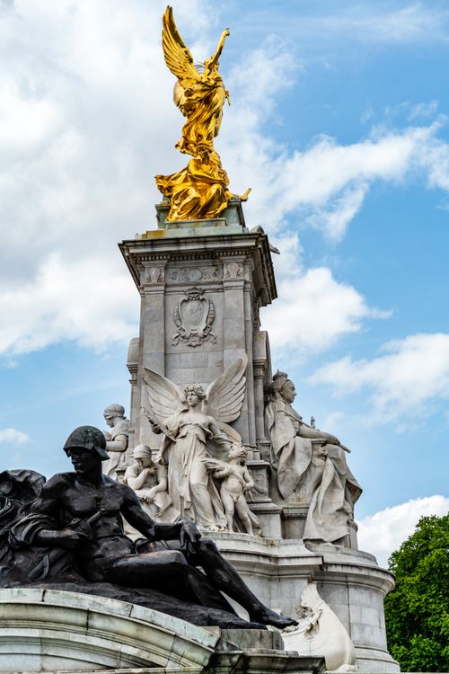 Free Statues of the Victoria Memorial under a cloudy sky in London, England. Stock Photo