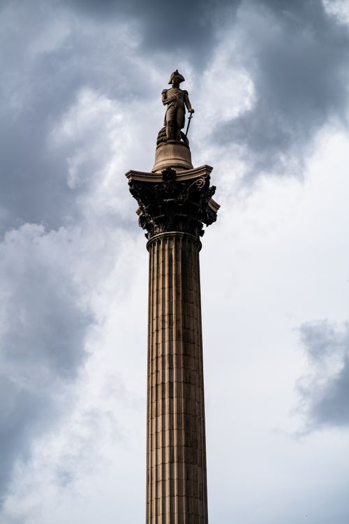 Free Dramatic view of Nelson's Column under a cloudy sky in London's Trafalgar Square. Stock Photo