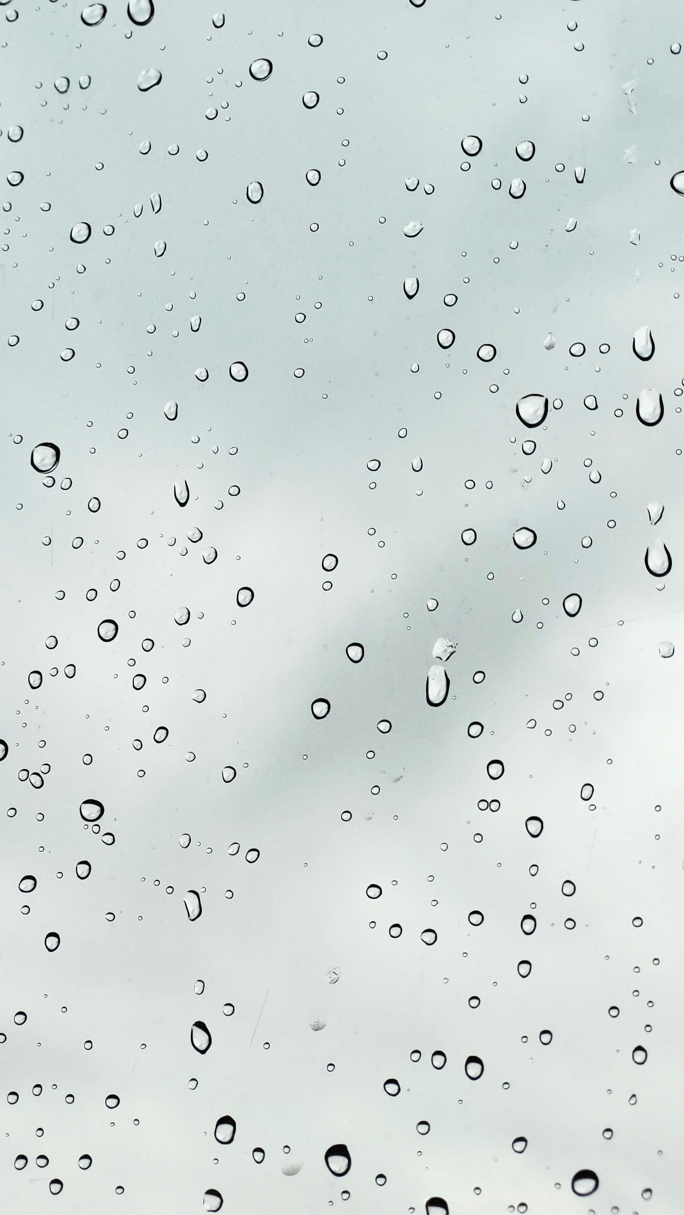 Gratis Primo piano di gocce di pioggia su una finestra con cielo coperto sullo sfondo, che mette in risalto gli elementi meteorologici. Foto a disposizione