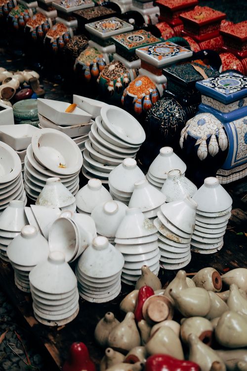 Free A vibrant display of stacked ceramic pottery at an outdoor market. Stock Photo