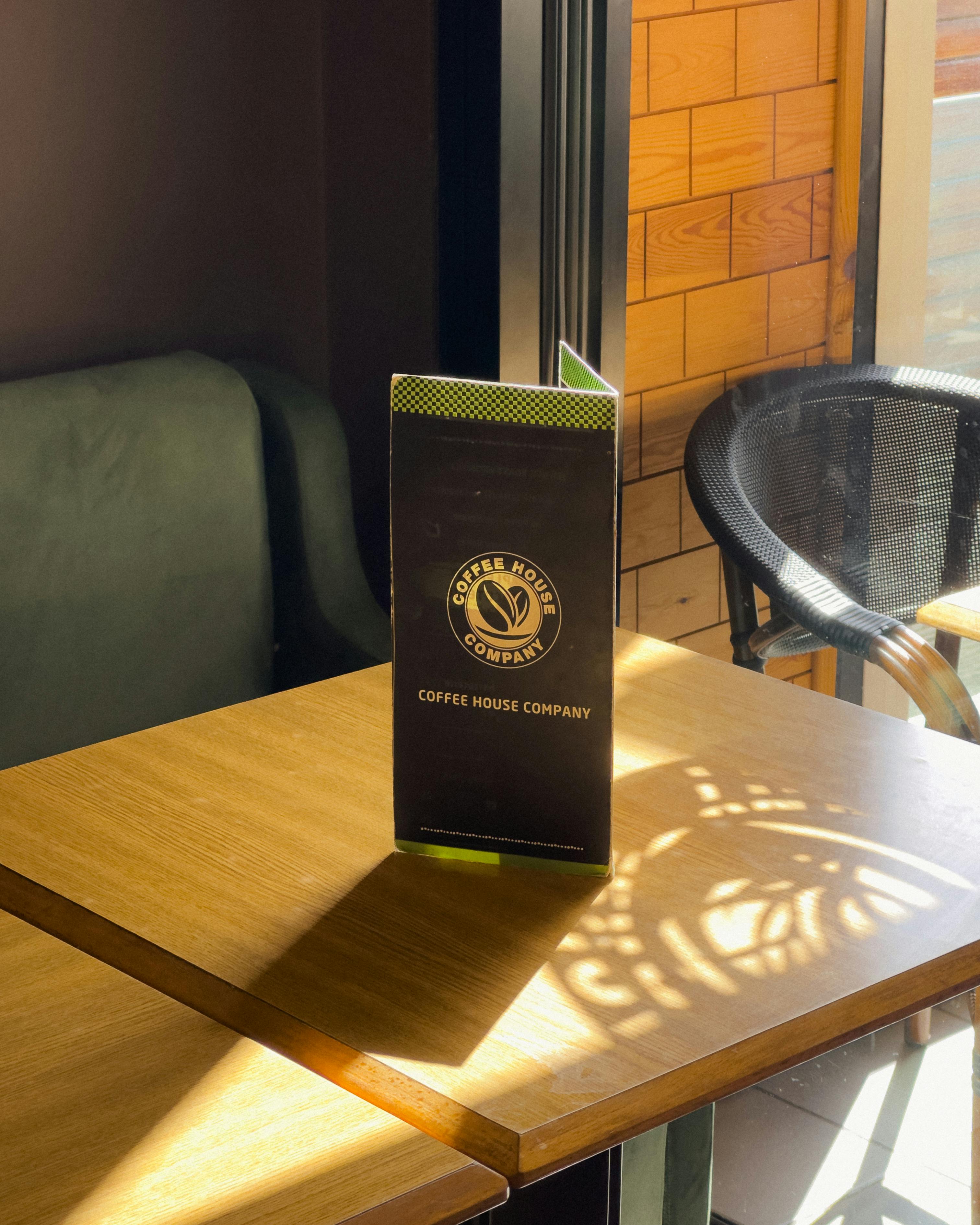 De franc Taula de cafeteria assolellada amb menú i ambient acollidor. Foto d'estoc