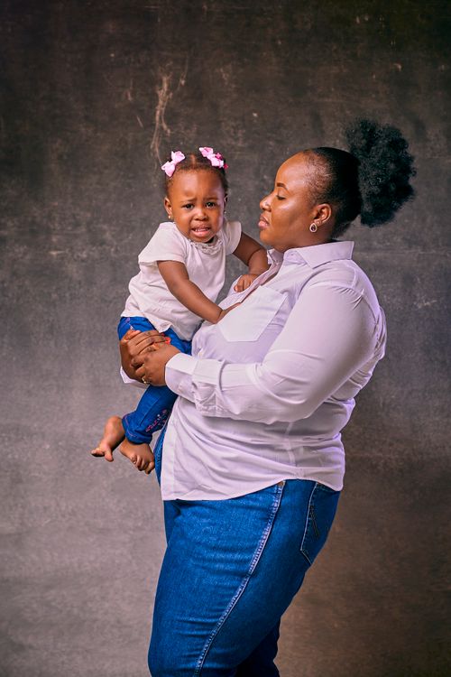 Free A mother soothes her crying toddler daughter in an indoor setting. Stock Photo