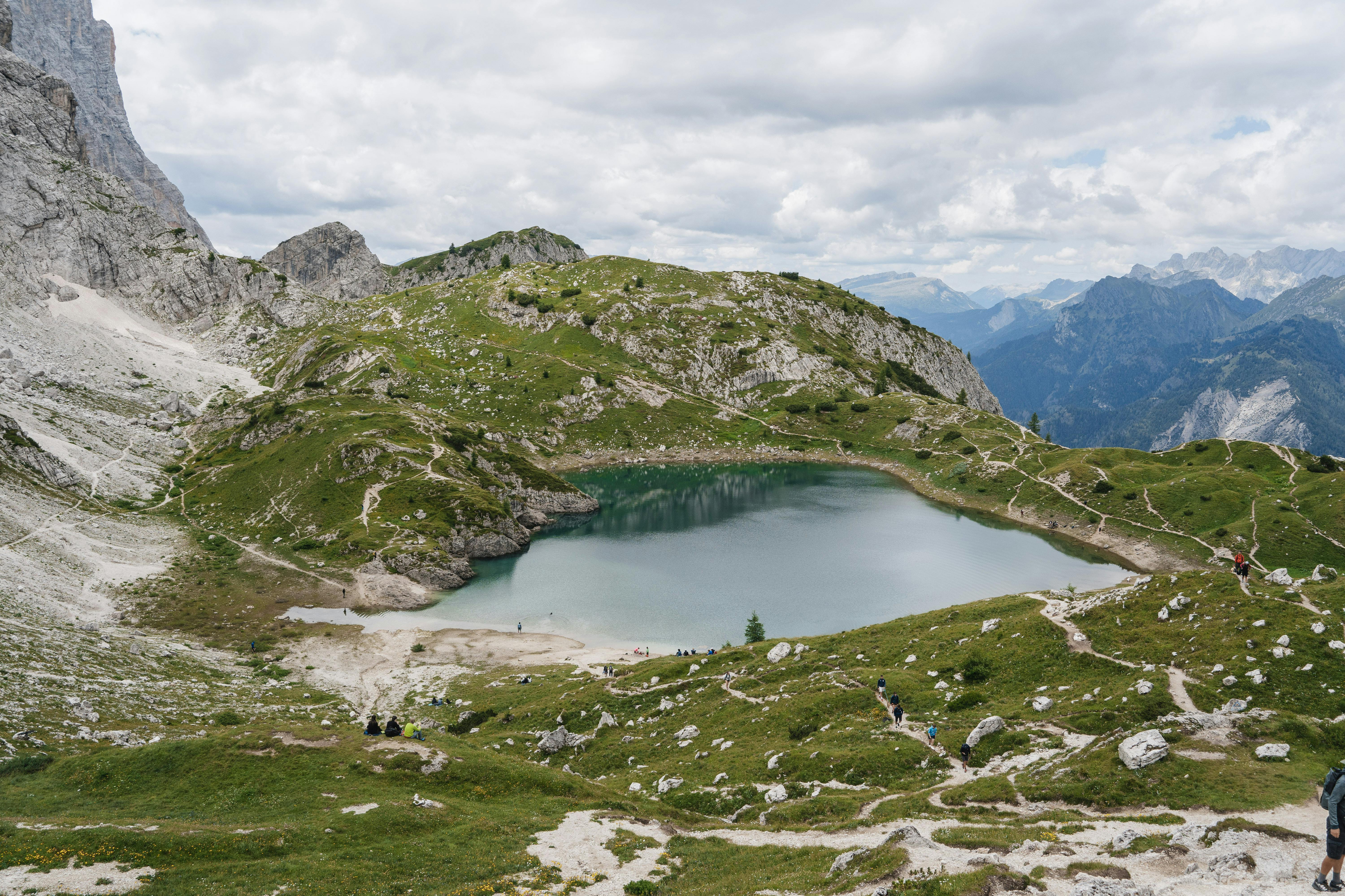 Beautiful alpine lake with rocky mountains and grassy slopes, perfect for hiking.
