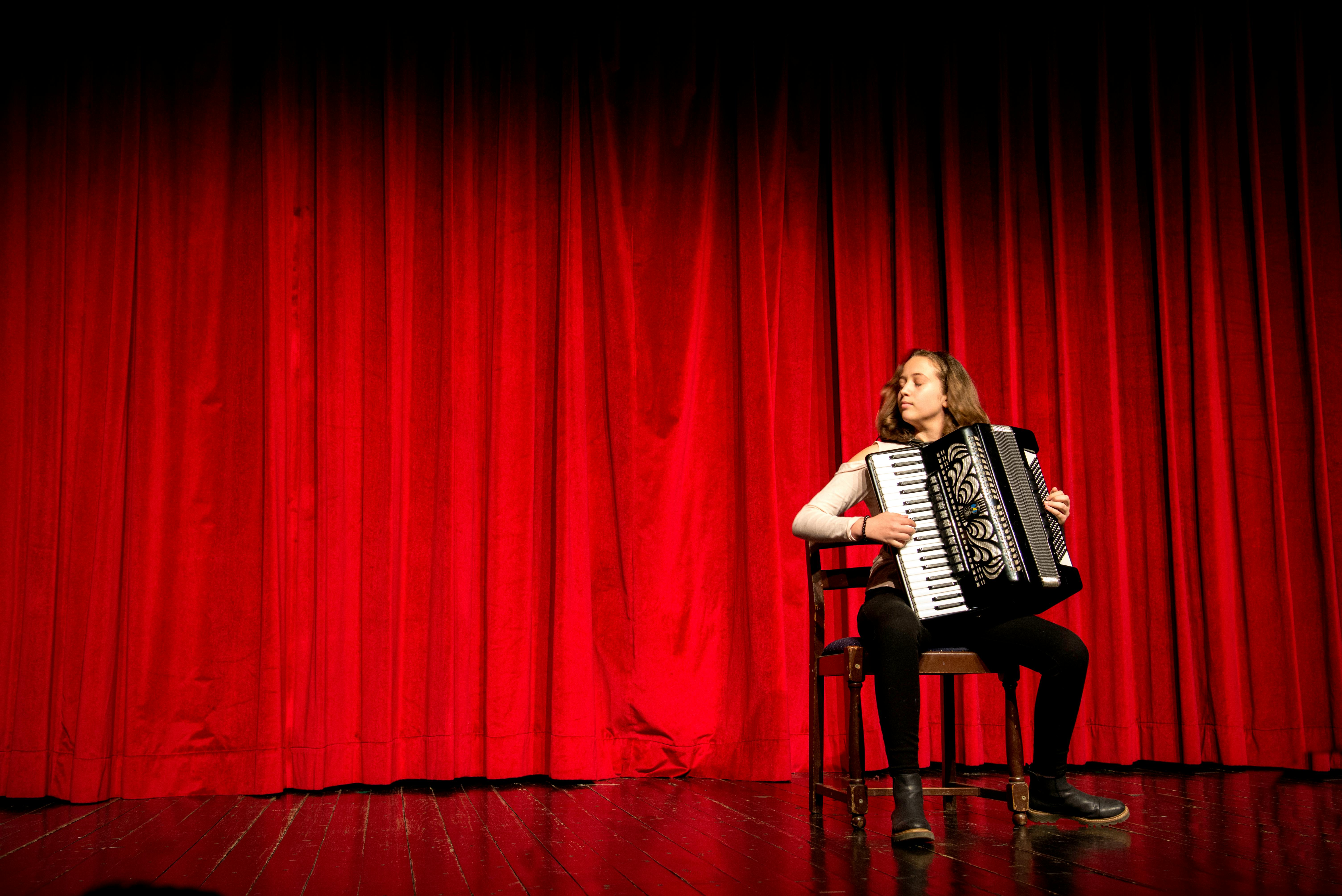 ฟรี คนกำลังเล่นหีบเพลงบนเวทีที่มีม่านสีแดงในเมืองโนวีซาด ประเทศเซอร์เบีย คลังภาพถ่าย