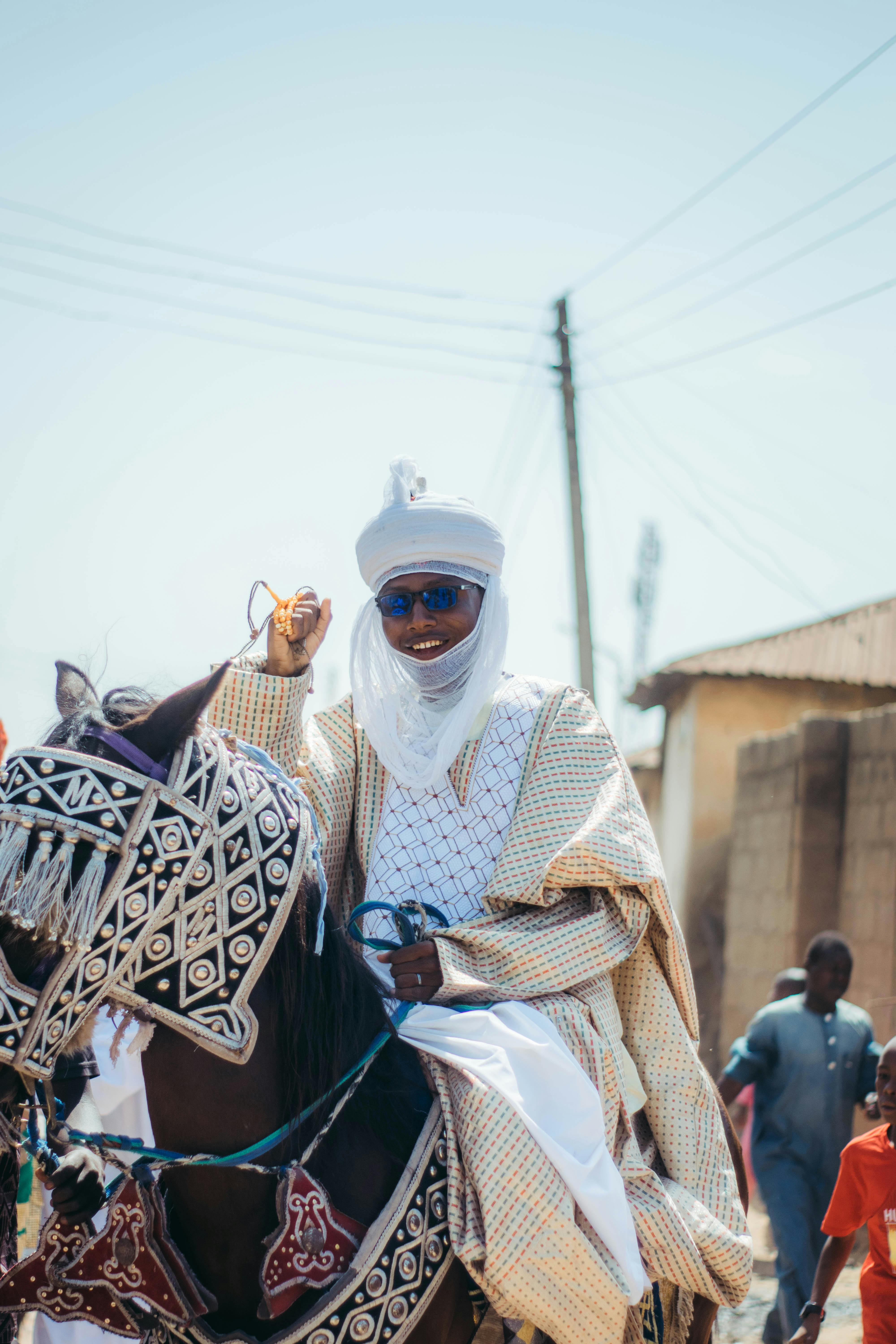 A traditional horseman dressed in ornate garb during a cultural festival in Nigeria.
