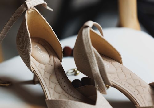 A detailed close-up of elegant beige high heel shoes with textured design, perfect for fashion enthusiasts.