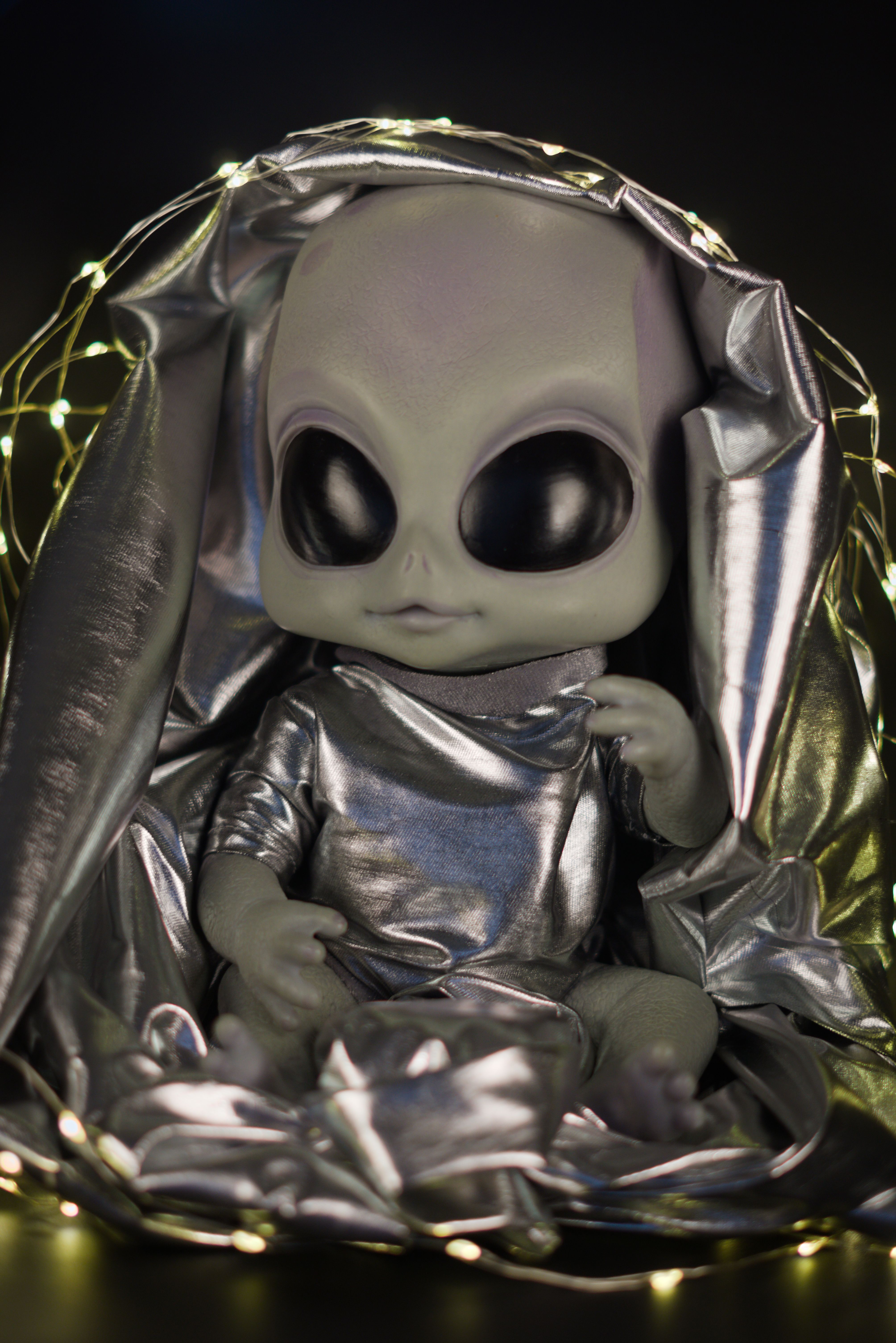 Silver Alien Doll Surrounded by Fairy Lights · Free Stock Photo