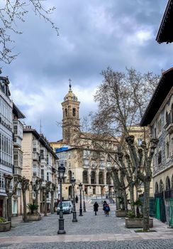 Charming street view with historical architecture and church tower in Vitoria-Gasteiz, Spain.