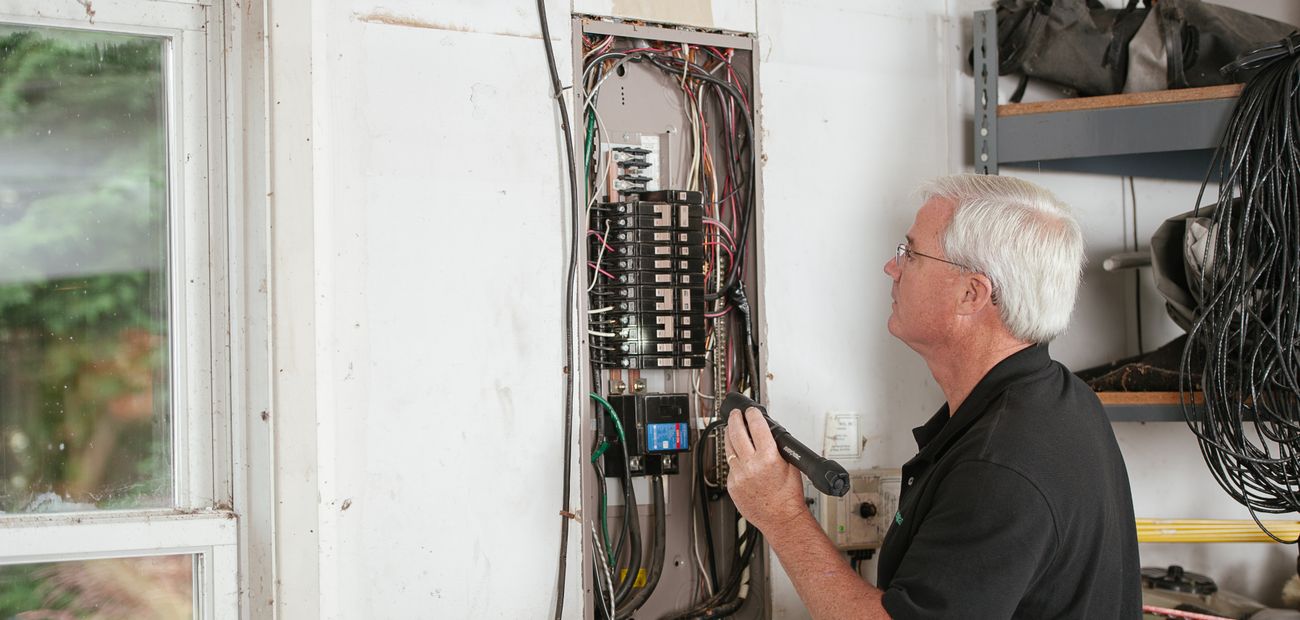 Électricien contrôlant un tableau électrique résidentiel
